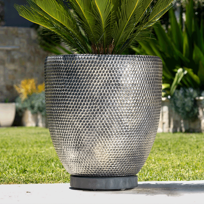 Image show a heavy pot with a plant trolley underneath and an animation that shows the omni wheels.